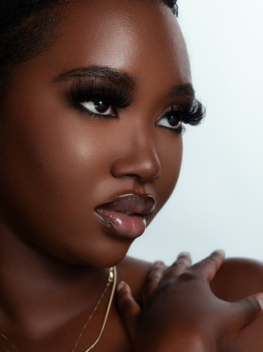 Close-up portrait of a woman wearing luxurious Fantasy strip eyelashes that mimic eyelash extensions, showcasing soft, voluminous lashes with a flawless makeup look.