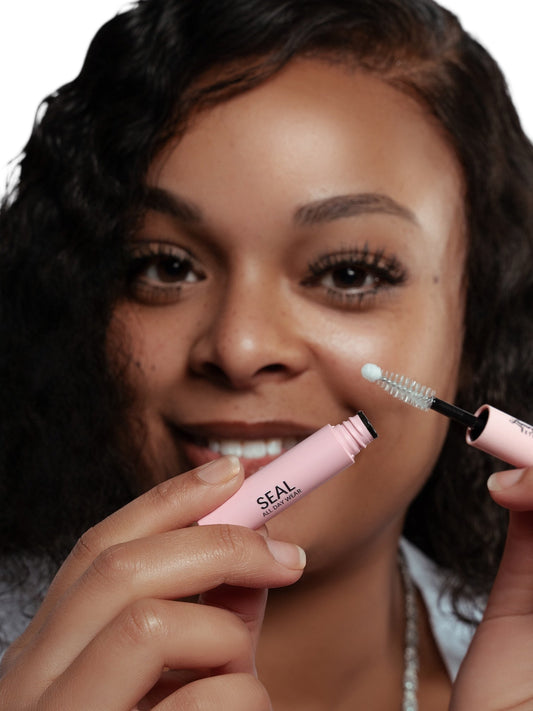 Woman holding Seal and Bond Glue for cluster lashes with applicator brush